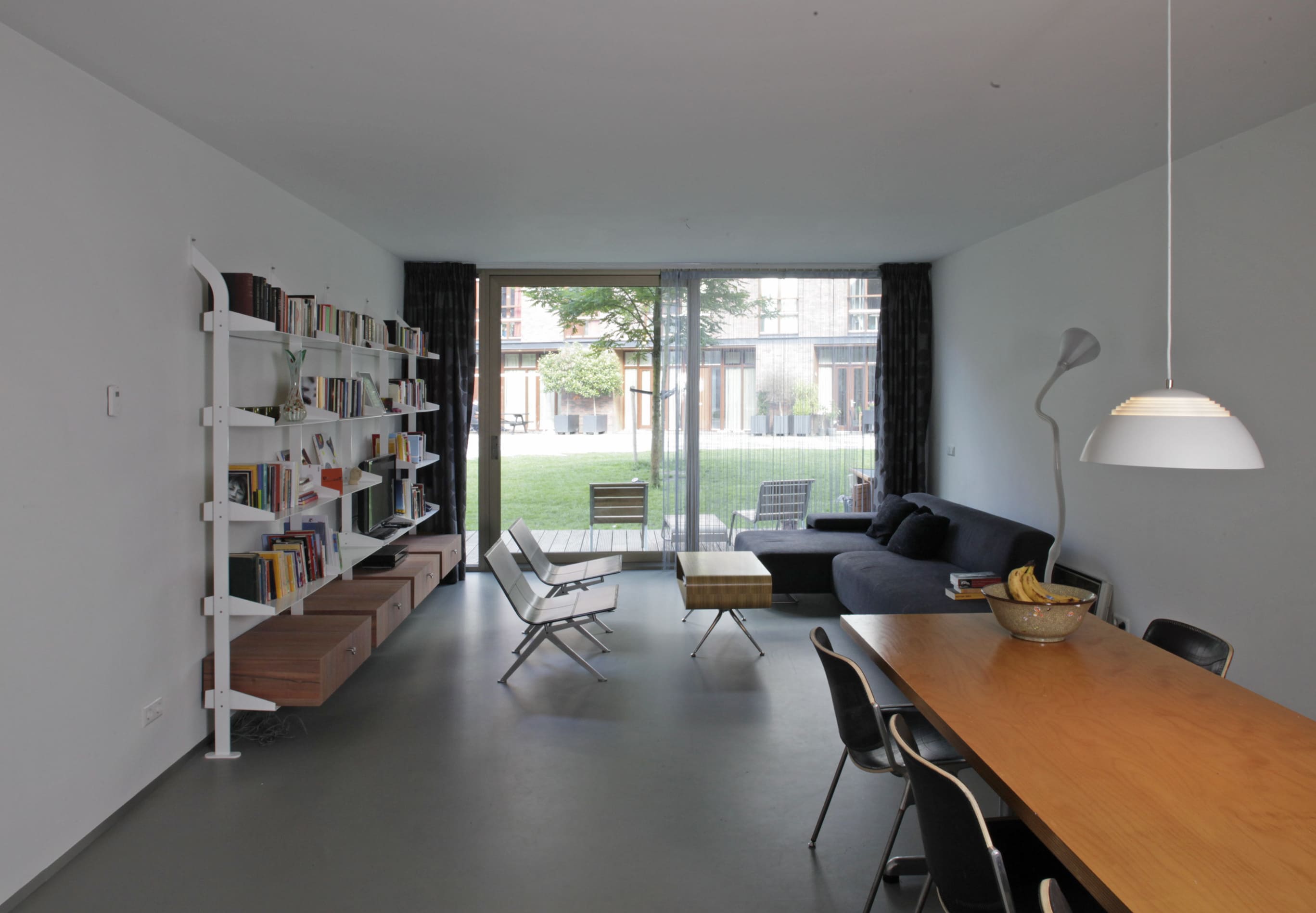 Interior living space in Blok K / Verdana opening directly onto a garden and the surrounding housing blocks.