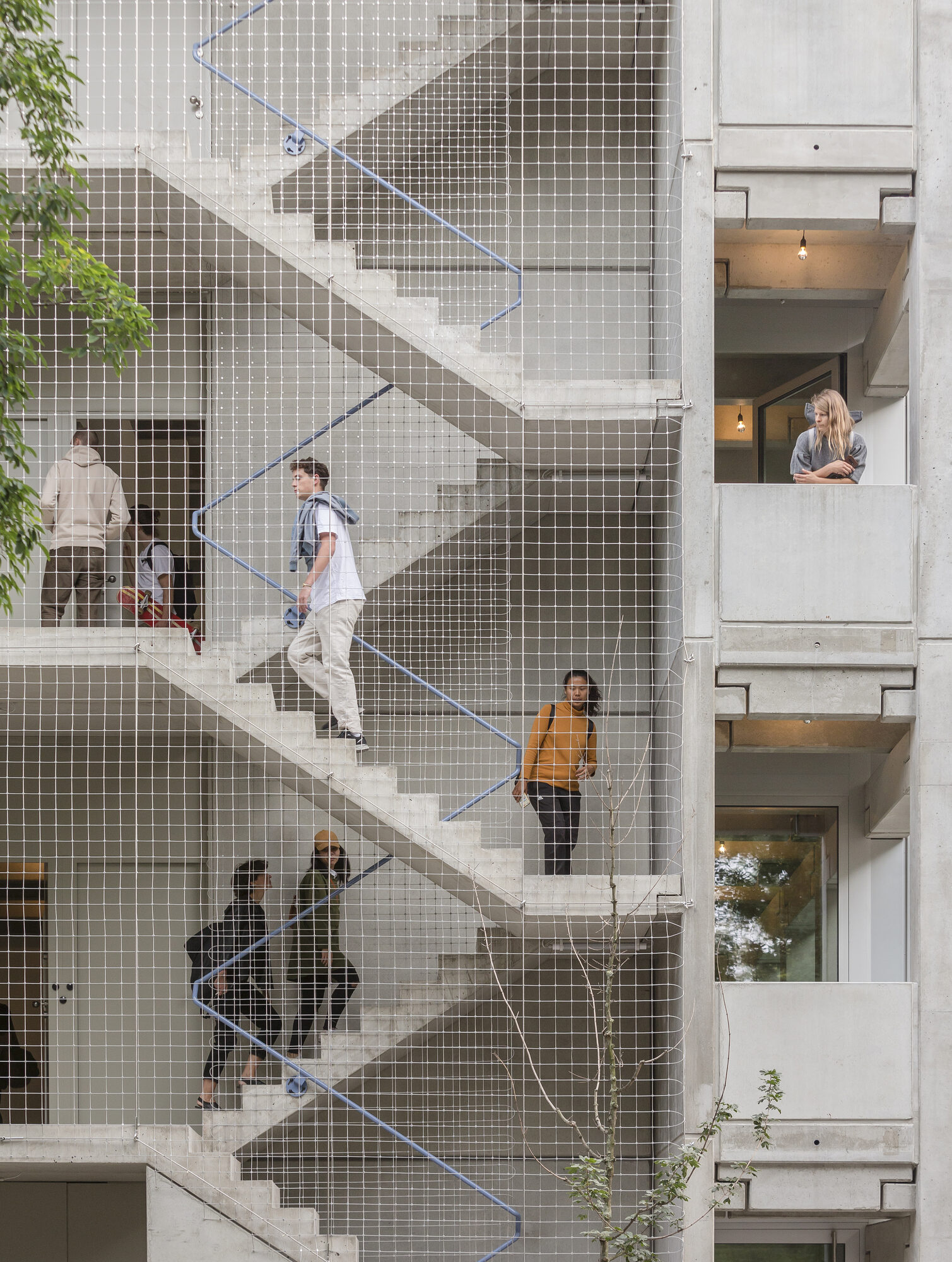Wohnregal interior staircase with exposed concrete structure and natural light from large facade openings