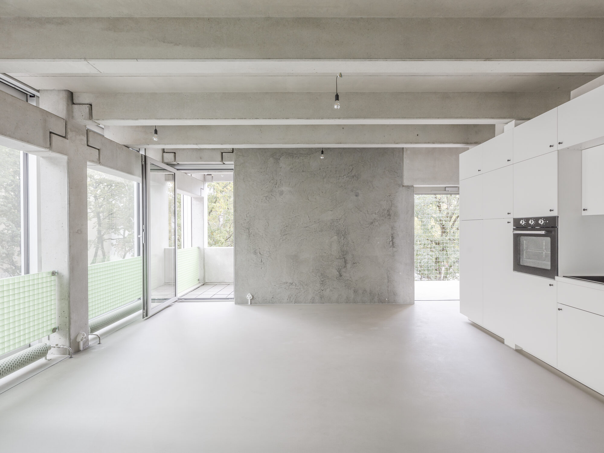 Open Wohnregal interior showing exposed precast concrete structure and large facade openings